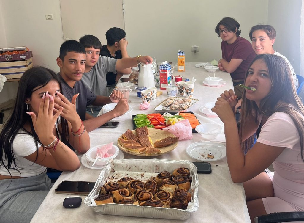 תלמדים יושבים ליד שולחן ואוכלים
