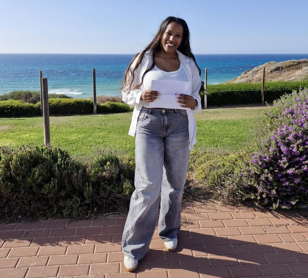 נערה וברקע דשא וים נשקף מרחוק