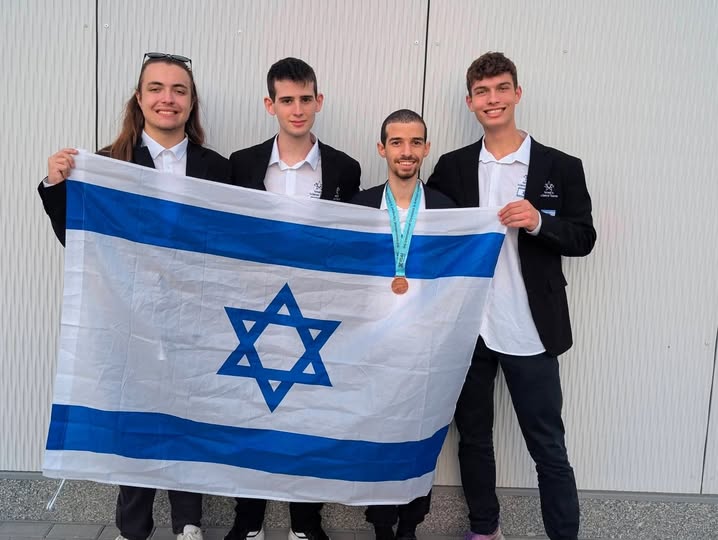 4 בני נוער בחליפות ומחזיקים את דגל ישראל